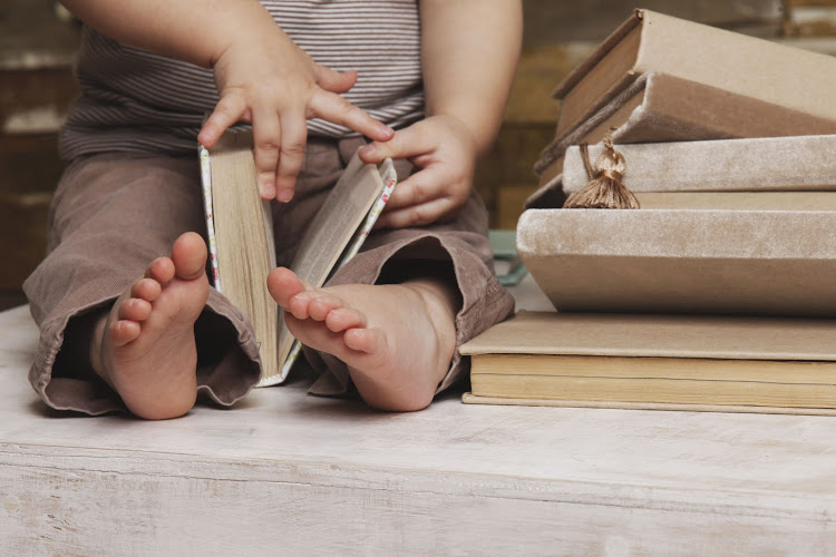 small feet of a child watching a book
